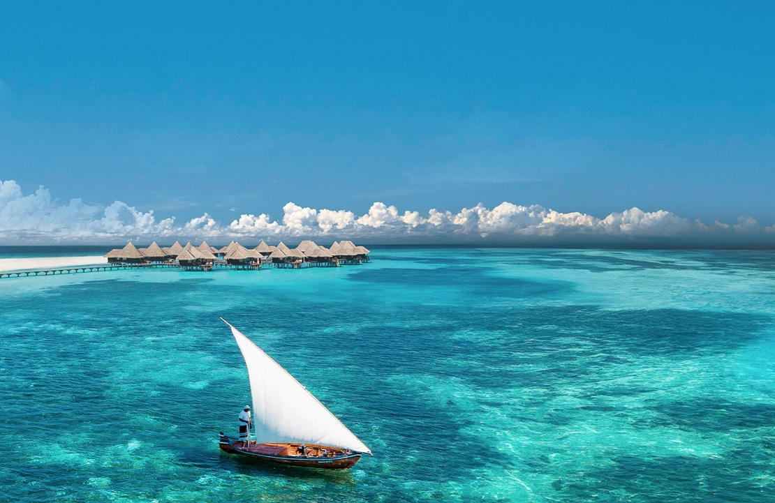 Voyage de noces aux Maldives - Un voilier voguant au large des villas sur pilotis du Coco Palm Hotel - Amplitudes 
