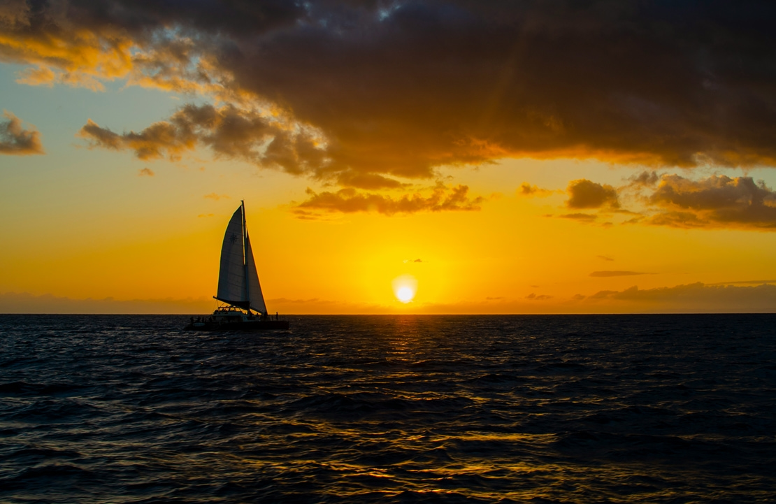 Croisière à Oahu - Un voilier voguant vers le soleil couchant - Amplitudes