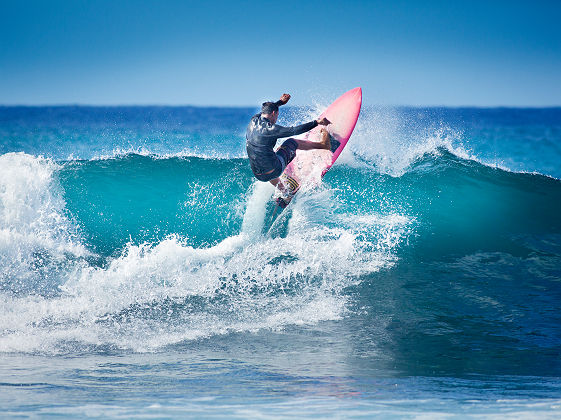 Hawaï - Portrait d'un jeune surfeur sur les vagues de l'île Kauai