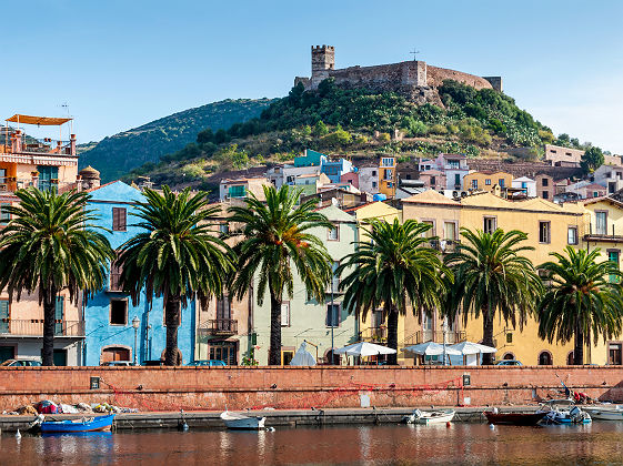 Sardaigne - Vue sur les bâtiments colorés au bord de la rivière Temo de la ville de Bosa et le château (arrière-plan)