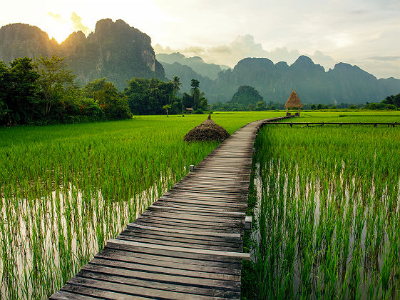 Coucher de soleil sur les rizières et les montagnes près de Vang Vieng - Laos