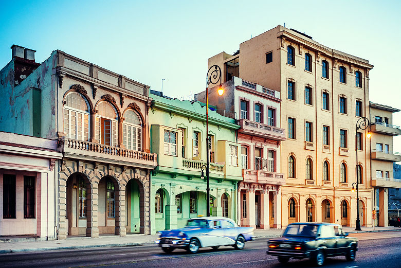 Cuba - Voitures vintages garées en face des bâtiments colorées historiques de La Havane