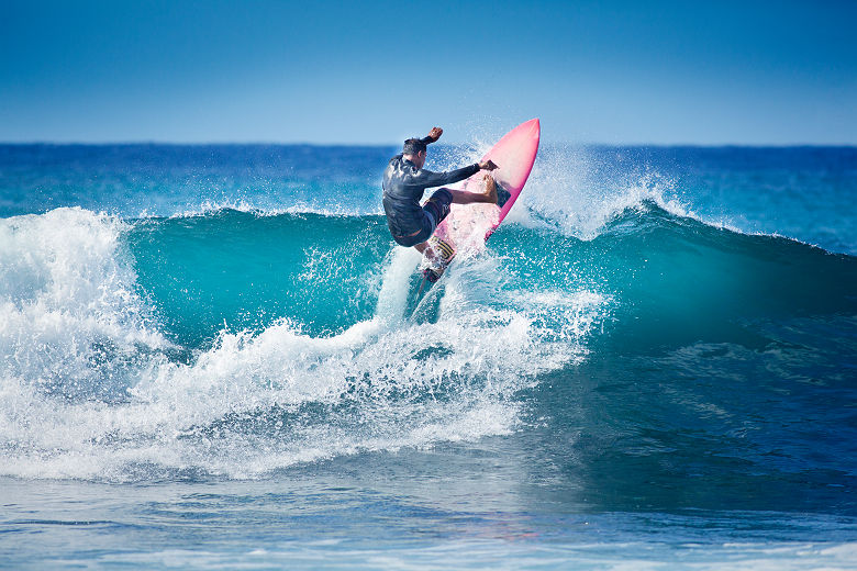 Hawaï - Portrait d'un jeune surfeur sur les vagues de l'île Kauai