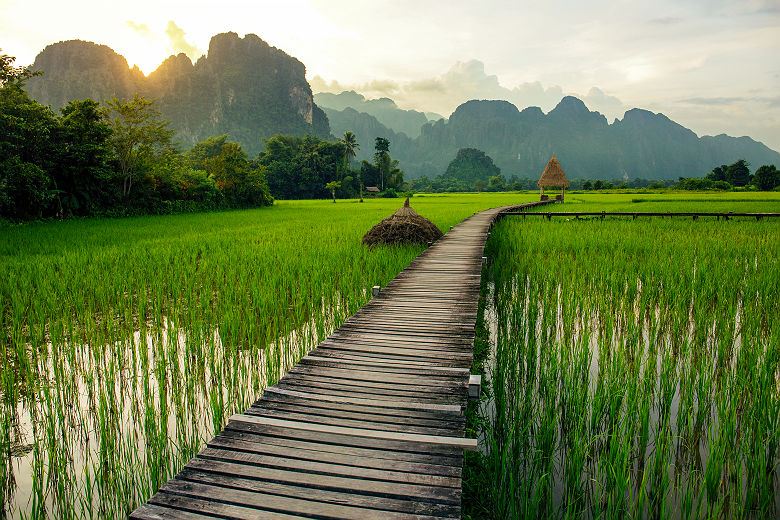 Coucher de soleil sur les rizières et les montagnes près de Vang Vieng - Laos