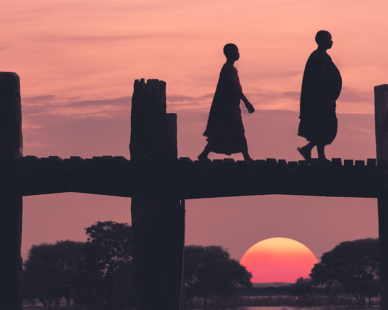 Deux moines marchant sur le pont de teck d'U Bein au coucher du soleil, Amarapura près de Mandalay - Birmanie