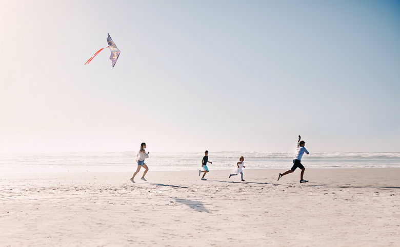Famille jouant au cerf-volant sur une plage