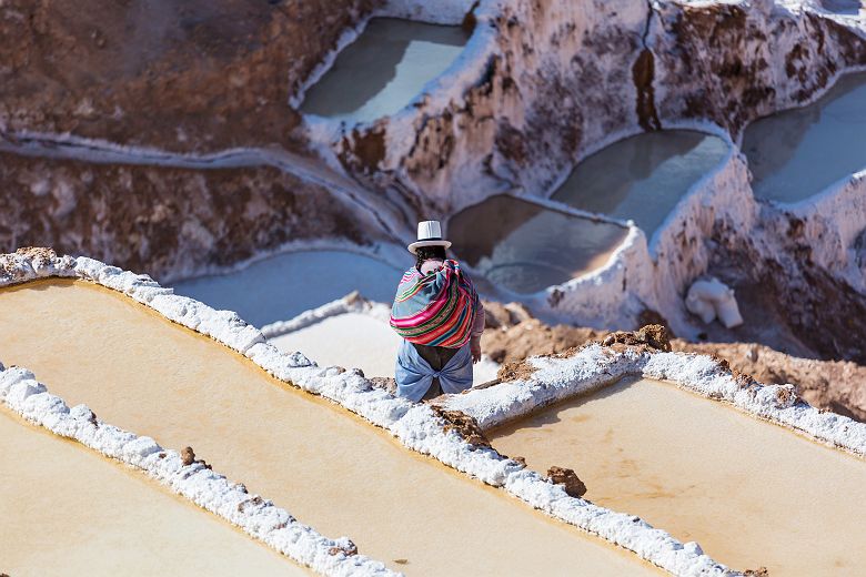 Pérou - Femme en habit traditionnel travaille sur les salines, Maras