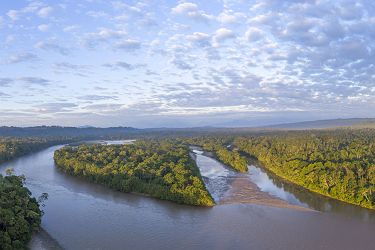 Aerial panorama of the Rio Napo at dawn in the Ecuadorian Amazon with the first rays of the sun illuminating the forest canopy