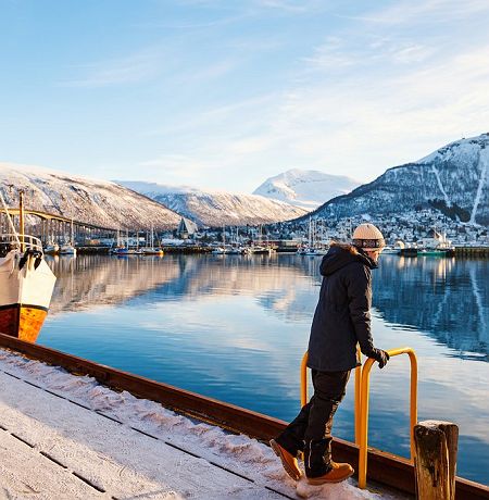 Teenage noy outdoors on winter day enjoying views of Tromso Norway