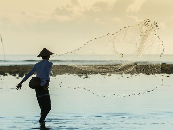 Bali - Portrait d'un pêcheur qui jette son filet dans la mer