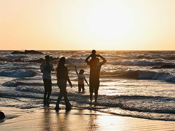 Famille sur la plage face à l'océan