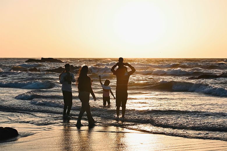 Famille sur la plage face à l'océan