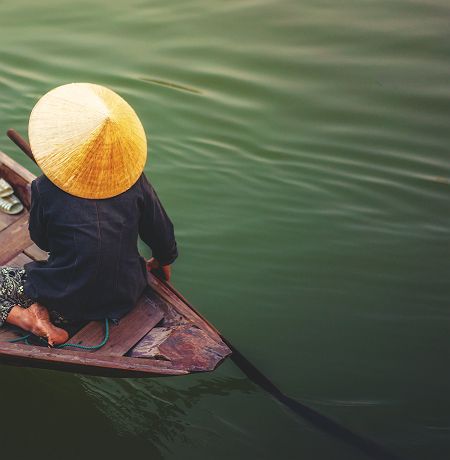 Vietnam - Portrait d'une femme qui rame dans son bateau sur le Mékong