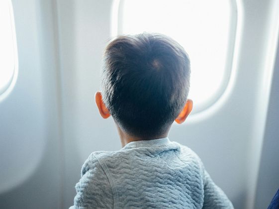 Enfant devant le hublot d'un avion 