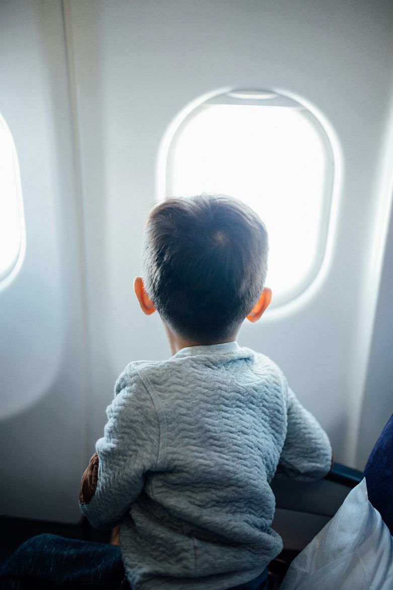 Enfant devant le hublot d'un avion 