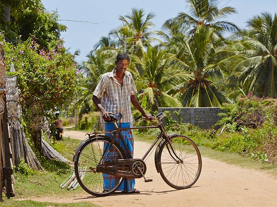 Homme avec un vélo dans un village typique du Sri Lanka