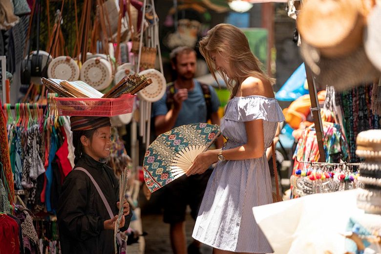 Une femme déambulant dans un marché d'art à Ubud