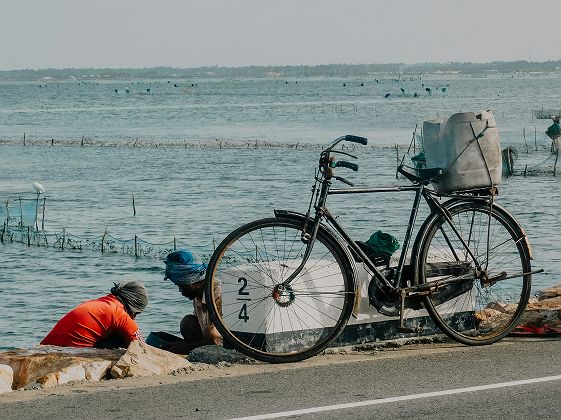 Un vélo garé sur le bord d’une route au bord de l’océan à Jaffna - Sri Lanka