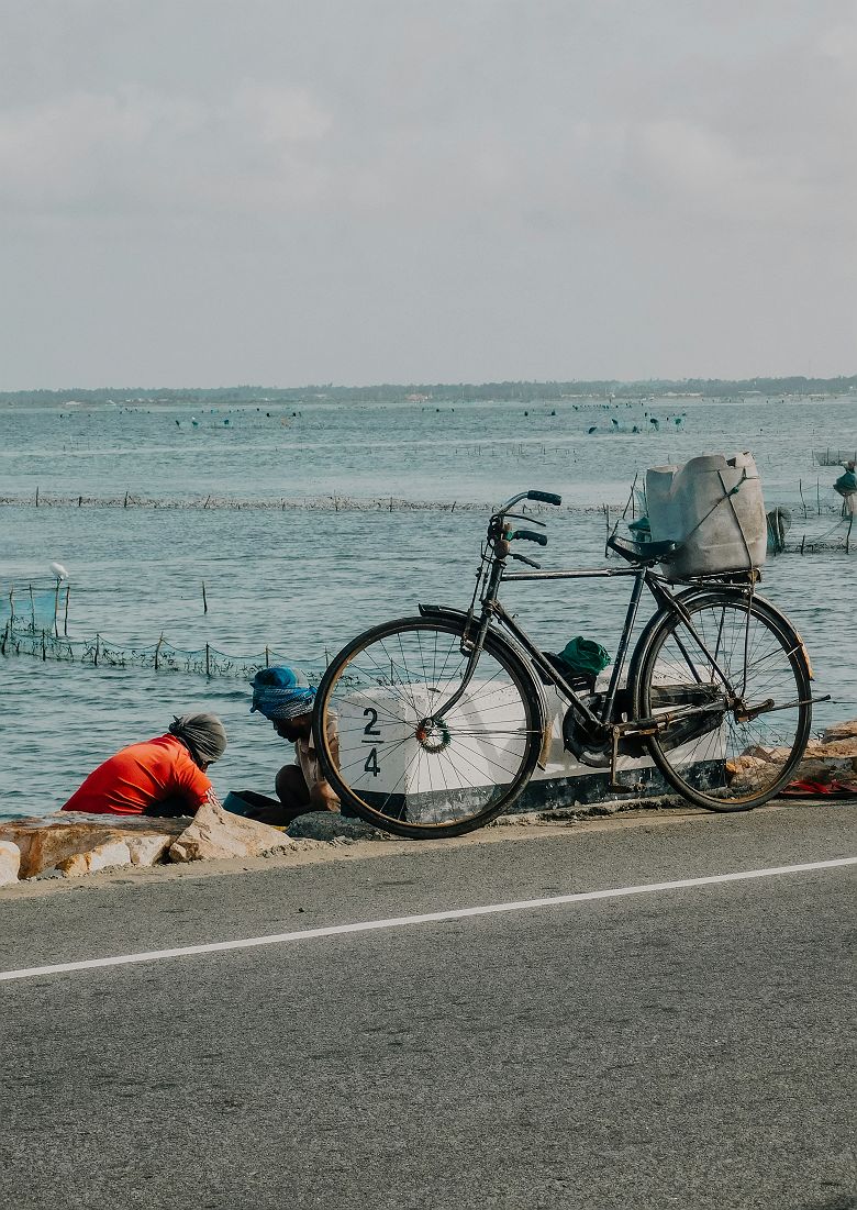 Un vélo garé sur le bord d’une route au bord de l’océan à Jaffna - Sri Lanka