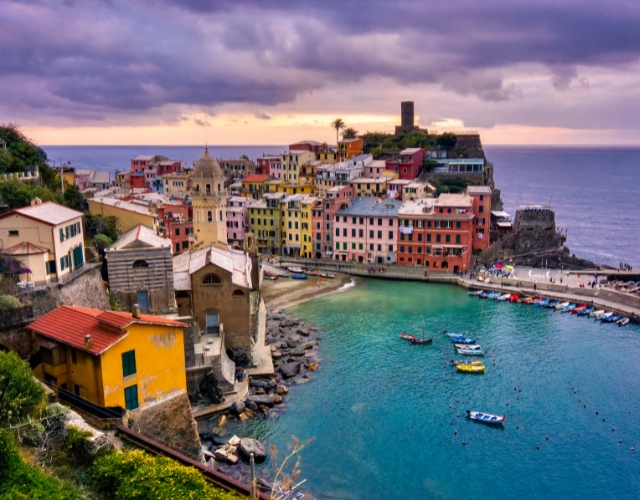bateaux aux abords du village coloré de Vernazza au coucher de soleil dans les cinque terre