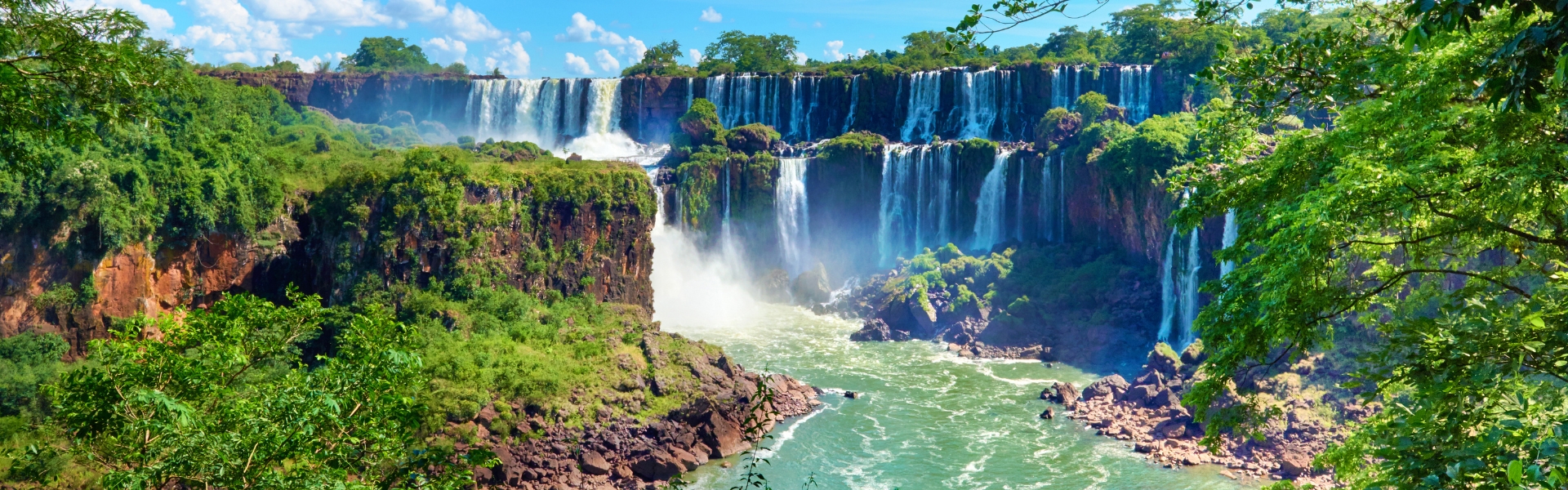 vue panoramique sur les chutes d'iguazú projetant une brume au-dessus du fleuve iguazú qui serpente dans la forêt subtropicale argentine
