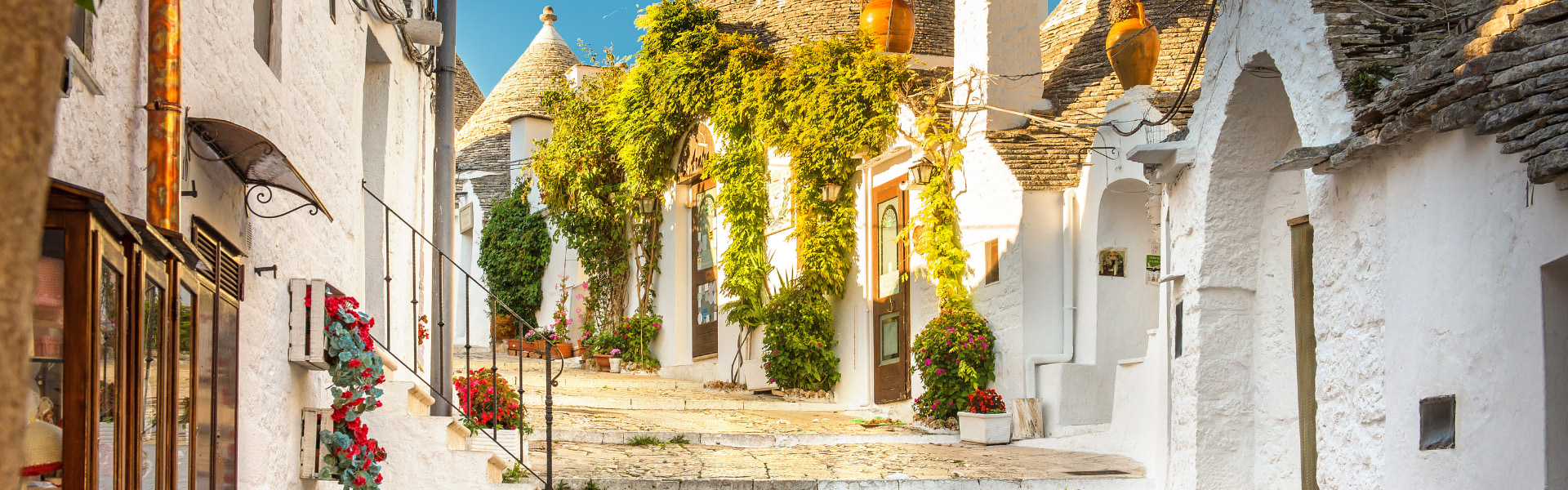 maisons trulli baignées de lumière bordant une ruelle pavée dans la ville d'alberobello dans les pouilles en italie