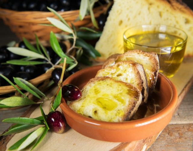 dégustation d'huile d'olive des pouilles sur des tranches de pain et olives noires