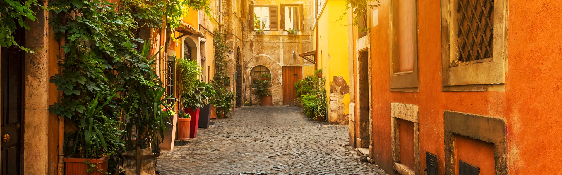 ruelle pavée et colorée ornée de plantes dans le quartier de trastevere à rome