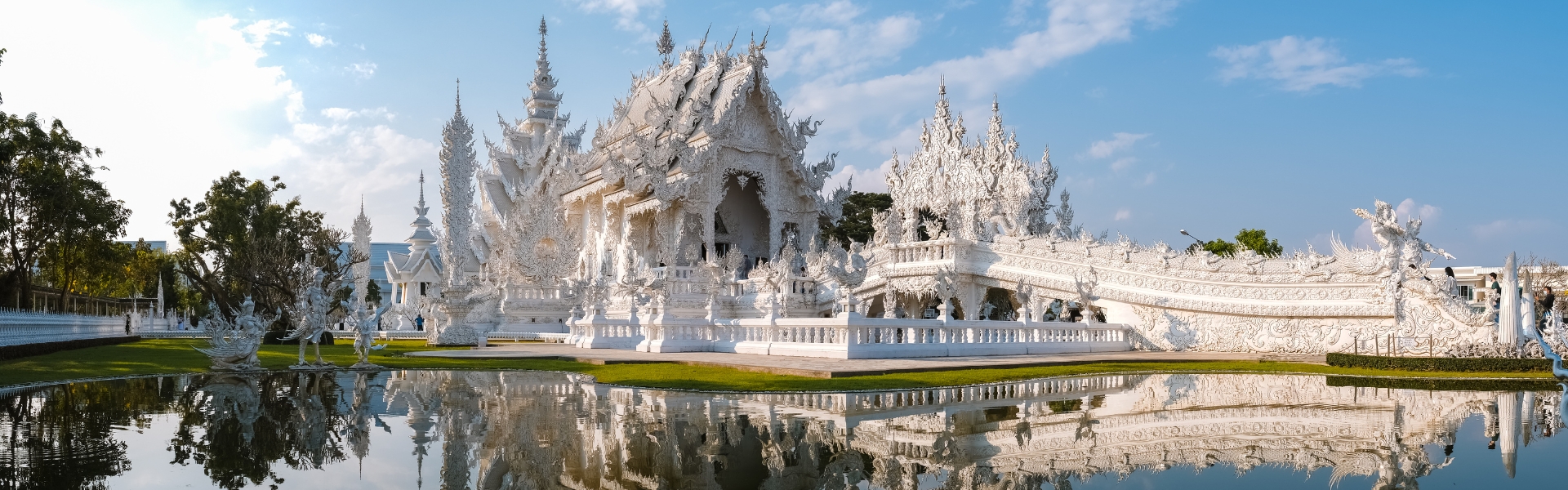 temple blanc le wat rong khun se reflétant dans un bassin à chiang rai dans le nord de la thaïlande