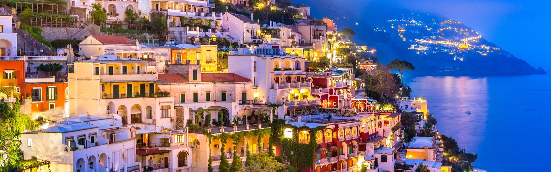 ville de positano à flanc de falaise bordée par la mer tyrrhénienne au crépuscule - côte amalfitaine
