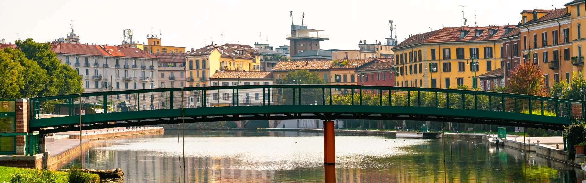 canal navigli bordé de batiments colorés et un pont au premier plan à milan