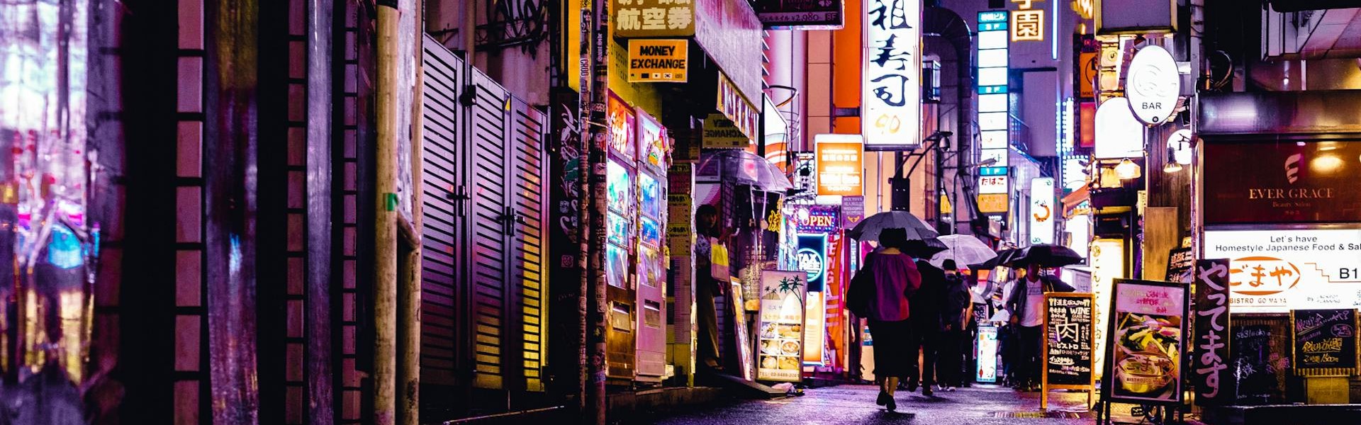 femme qui marche sous la pluie dans les rues de tokyo pendant la nuit