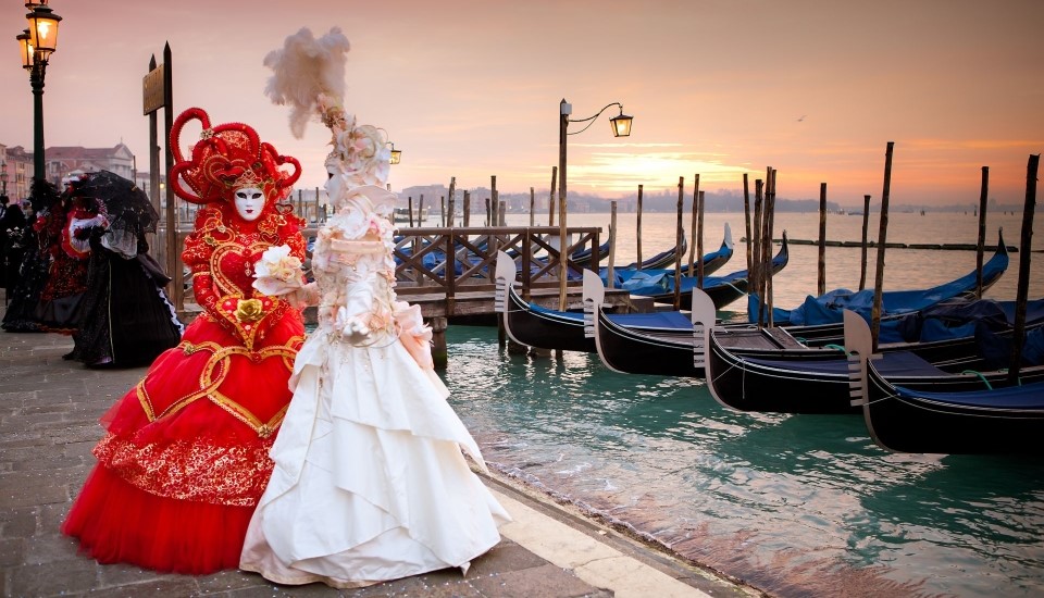 personnes déguisées pour le carnaval de venise au bord de la lagune au coucher du soleil