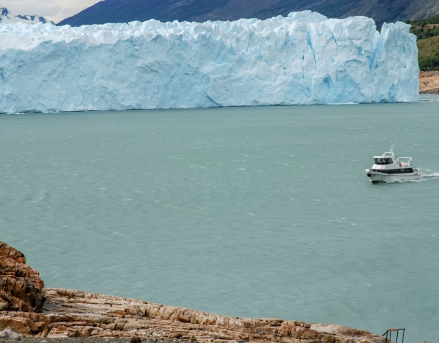 petit bateau qui traverse le bras du lac argentino appelé brazo rico, avec le glacier perito moreno en arrière-plan