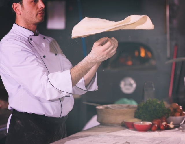 pizzaïolo qui lance la pâte à pizza - grands lacs italiens